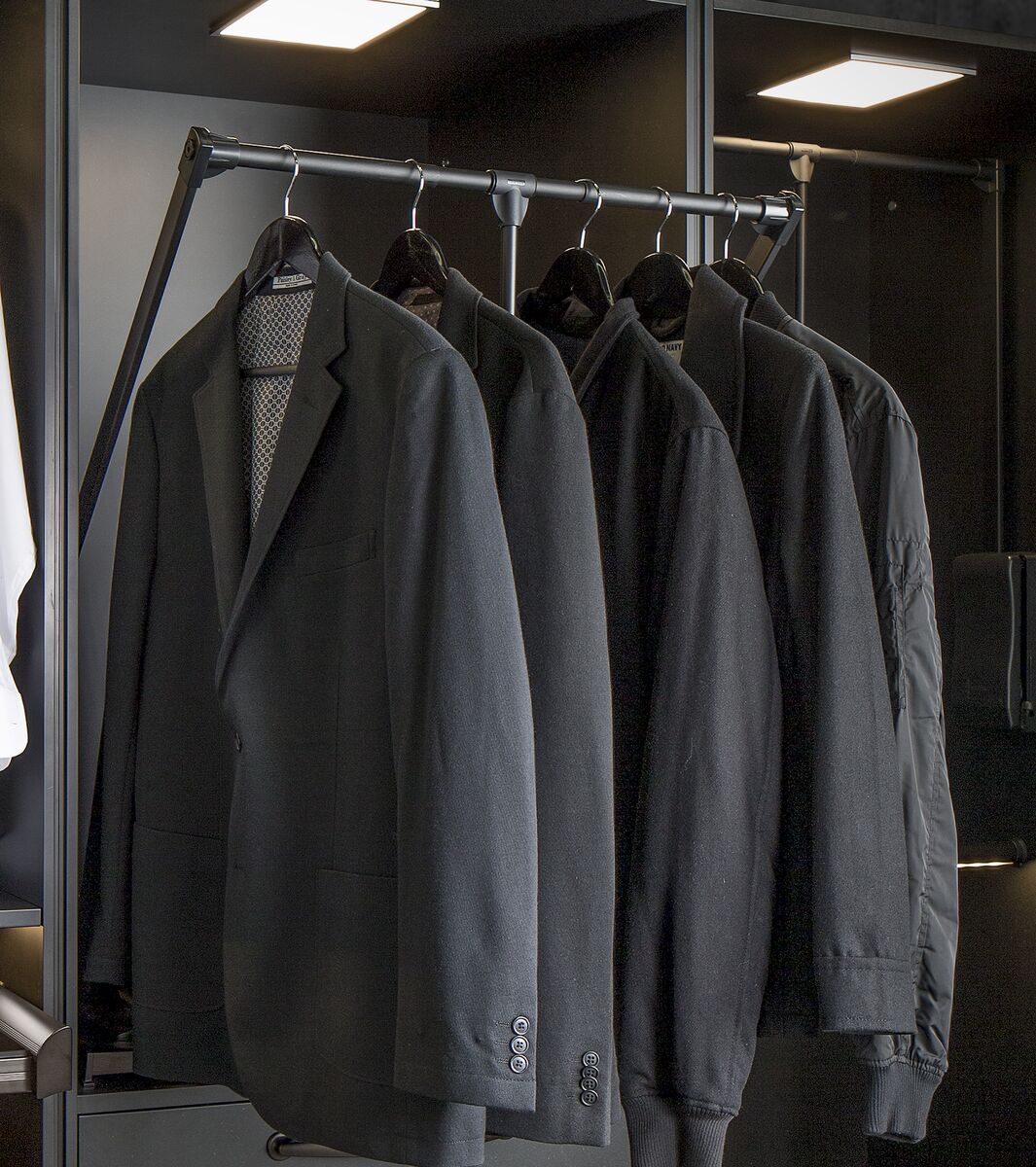 Pull-down hanging rod with suits in dark closet