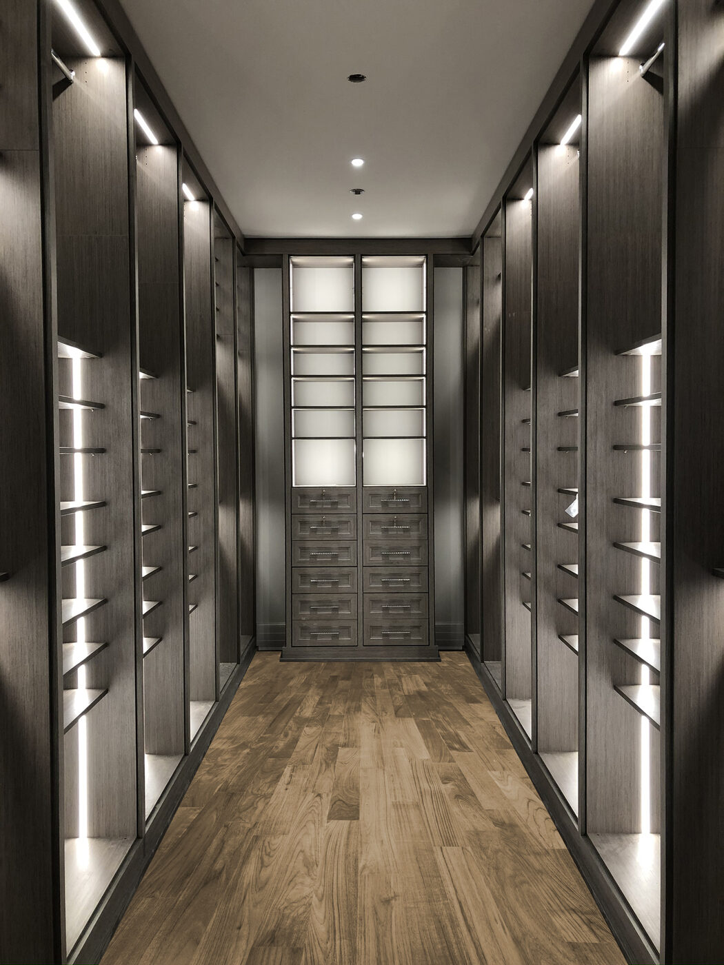 Dark custom walk-in closet with LED lighting